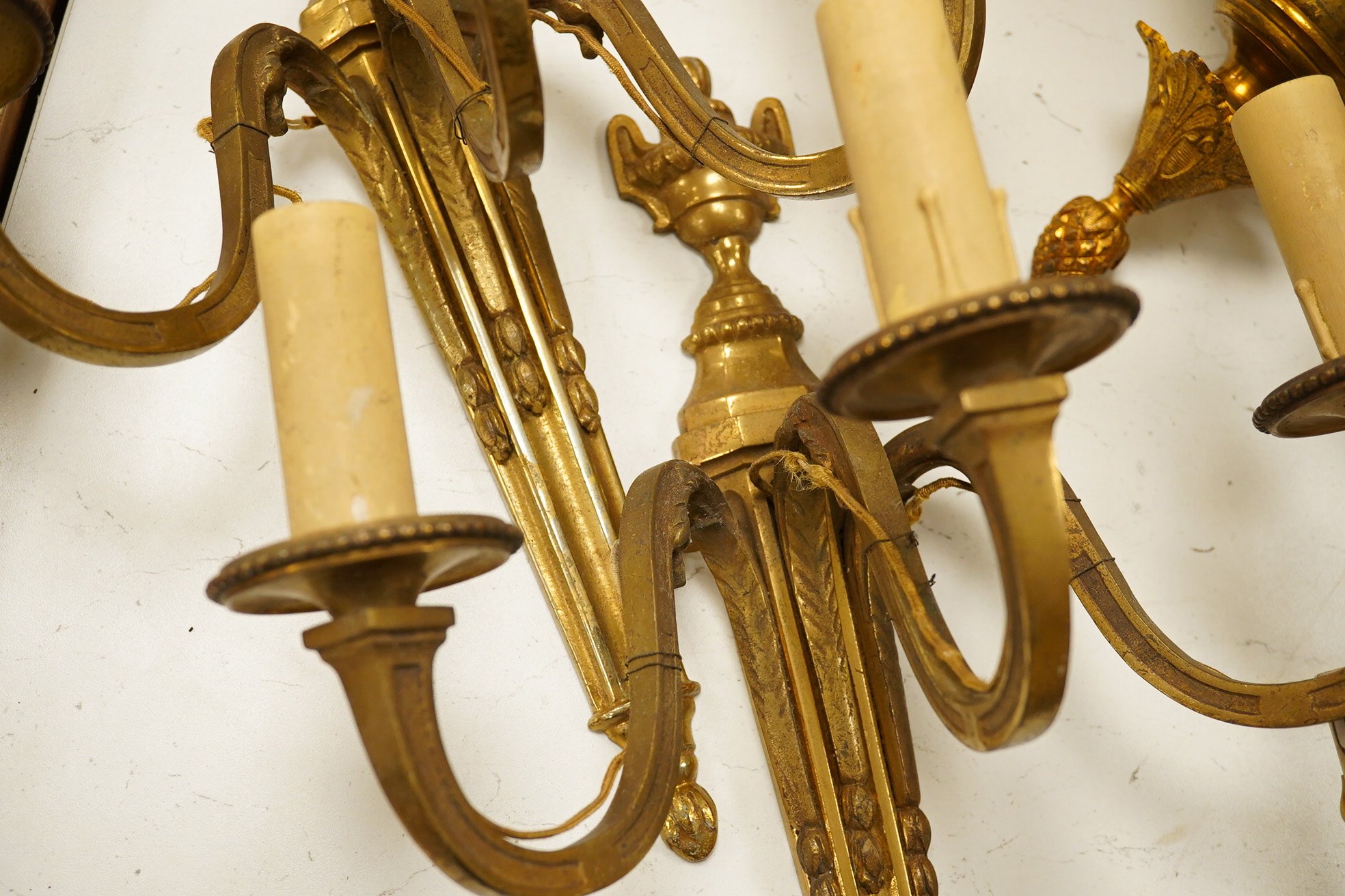 An ormolu ceiling light, a pair of three branch sconces and two pairs of two light sconces, largest 38cm high. Condition - variable